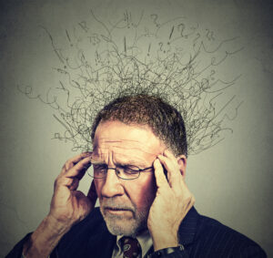 Closeup sad senior elderly man with worried stressed face expression looking down with brain melting into lines question marks.